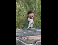 Woman in white floral dress tiktok dance on the rocks