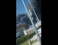 Black smoke from fire covers blue sky