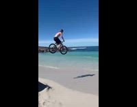 Guy ride bike on ramp towards beach