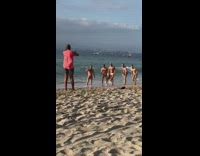 Five men in their briefs with sunglasses run at the beach