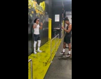 Guy takes picture of friend in front of graffiti wall at the gym