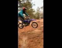 Guy rides dirt bike off hill 