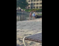 Woman in beige bikini tiktok dance on the beach