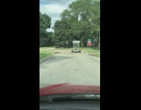 Woman driving red car sees huge shopping cart driving