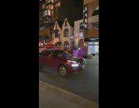 Girls pose in pink light on side walk