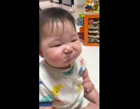 Adorable baby makes sour face tasting yogurt