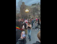 Woman dancing with a dildo candle in circle of people