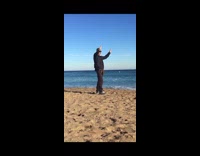 Blue jacket guy peace sign beach sand