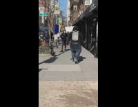 Guy walks down sidewalk with jeans sagging