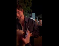 Celebrity holds and pets puppy at premiere