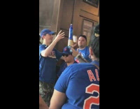 Mets fan balances two beer cans and one beer bottle on guys head at bar blue jerseys