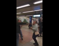 Group of strangers dance and sing together to music on speakers in subway station