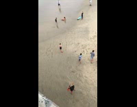 Collab Kook Of The Day - guy holding selfie stick taking picture of girl at beach 