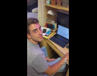 Guy backwards white hat talking to friend on laptop