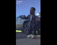 Short guy dances by parked truck