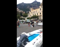 Woman in bikini takes picture in front of pink building