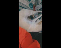 Girl sits on couch next to white dog 