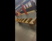 Guy wearing orange coat dances subway platform 