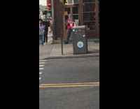 Mouse red jersey costume stands at the corner of street outside store