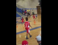 Little boy scores point for basketball team 