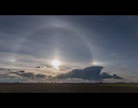 Sun with halo sets on horizon sunset