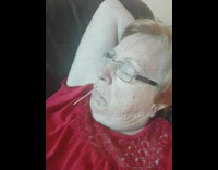 Grandma sleeps on couch with toothpick dangling out of her mouth