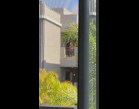 Woman in bikini selfie video at the apartment balcony
