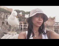White bird pecks at womans shoulder as she takes a selfie