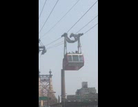 a man seen riding on top of red gondola 