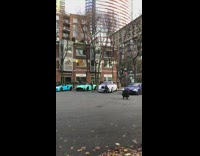 Guy squats and poses by white car