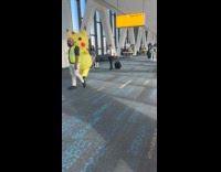 Person wears pikachu inflatable costume at airport