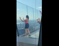 Collab IITW - Woman pink top raise arms building rooftop