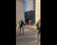 Man in orange suit poses with owl