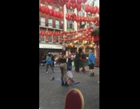 Woman split headstand  yoga mat Chinatown lanterns