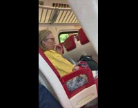 Woman yellow shirt plucks upper lip peach fuzz hair on train