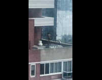 Guy only black shoes socks poses rooftop 