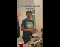 Guy at party eats chicken and pretends to take shot 