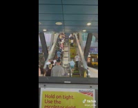 Old man walks up the down escalator in the train station