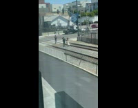 Couple hold hands walk on train tracks