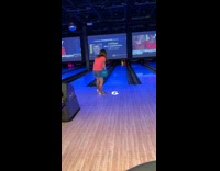 Girl pink shirt drops bowling ball backwards