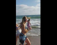 Man in swim suit dances with a kelp at the beach