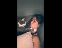 Woman talks while cat kneads her neck