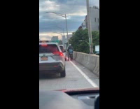 Man ride bike on bridge beside cars
