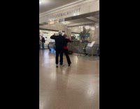 Tourist couple dances to man playing violin