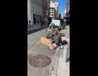 Homeless man holds funny sign on sidewalk