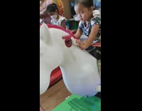 Girl on mechanical horse ride is unimpressed