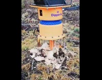 Yellow machine drills breaks removes tree stump