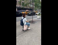 Collab WINY - Woman rides motorized luggage on the sidewalk