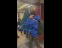 Guy wearing christmas tree at subway station