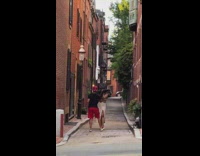 Woman in white dress black hat poses on the alley